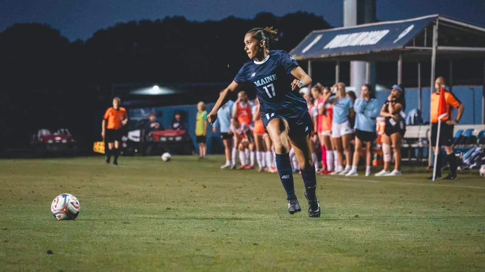 Player from Maine taking a corner kick on field Player from Maine taking a corner kick on field