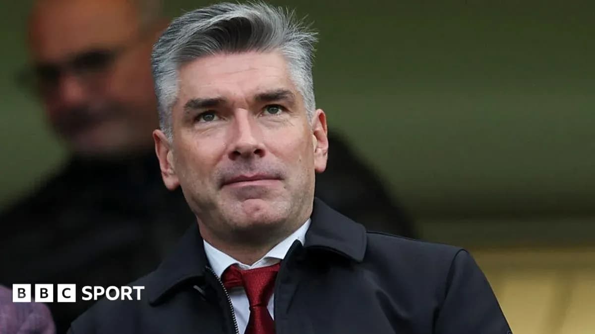 Man in suit observing from stands at a match Man in suit observing from stands at a match