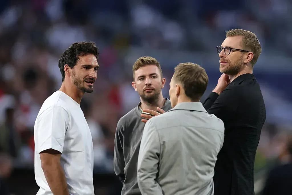 Four men conversing on a sports field Four men conversing on a sports field