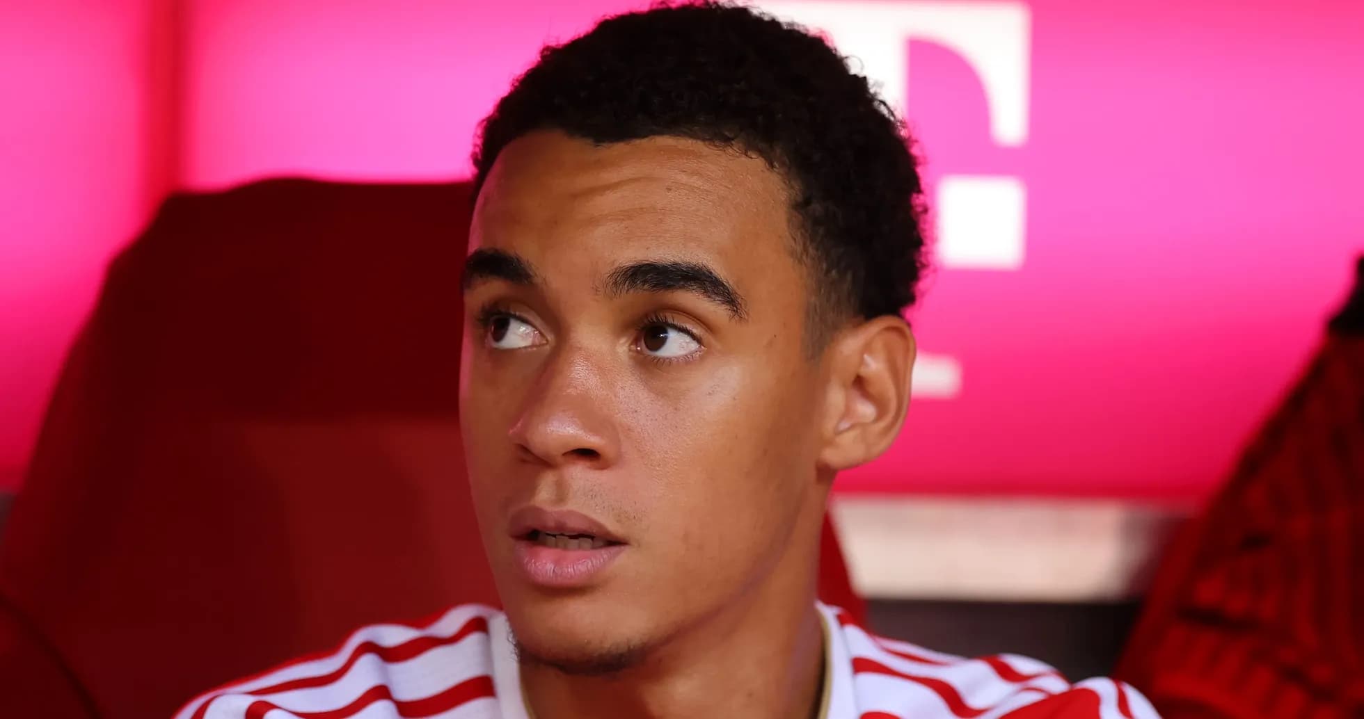 Player sitting on bench with focused expression Player sitting on bench with focused expression