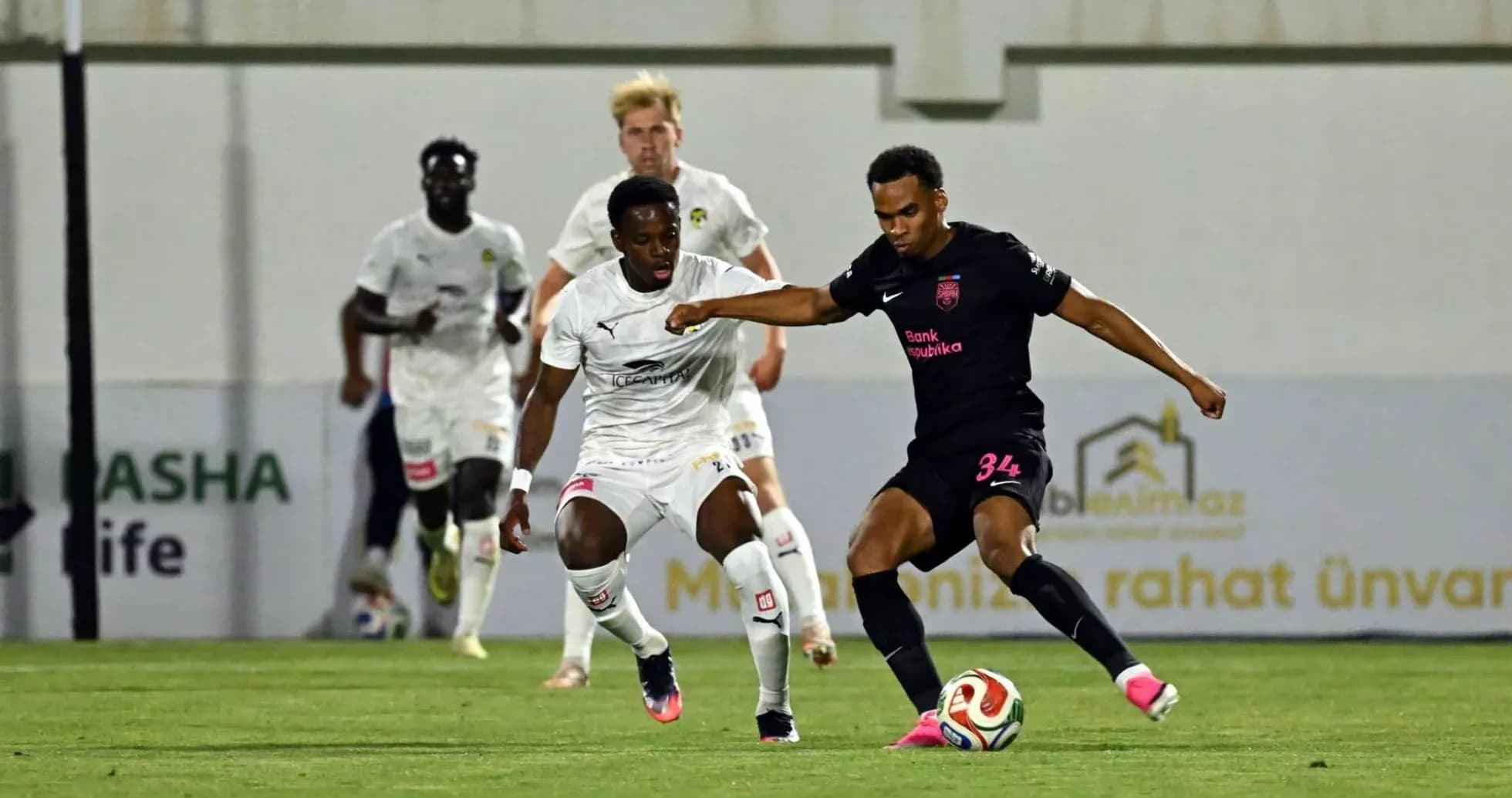 Player in black jersey dribbling past opponent Player in black jersey dribbling past opponent