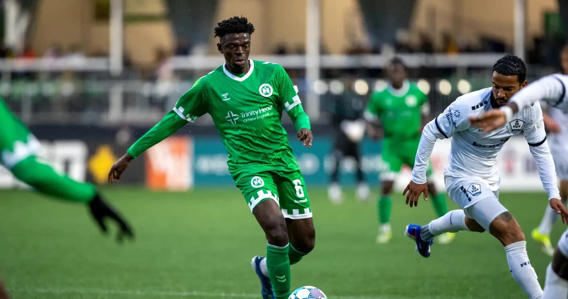 Player in green jersey dribbling the ball Player in green jersey dribbling the ball