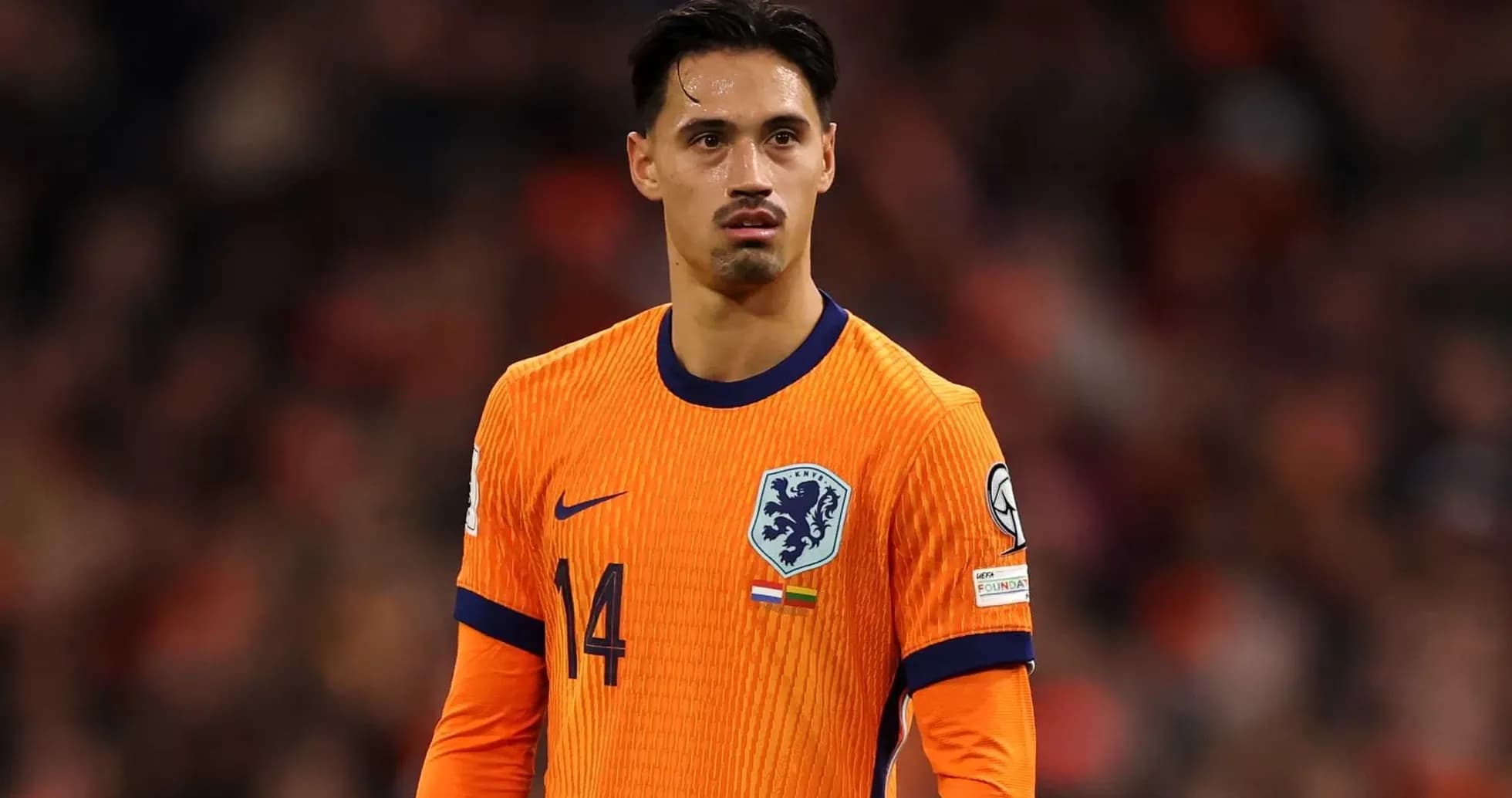Player in orange kit during football match Player in orange kit during football match