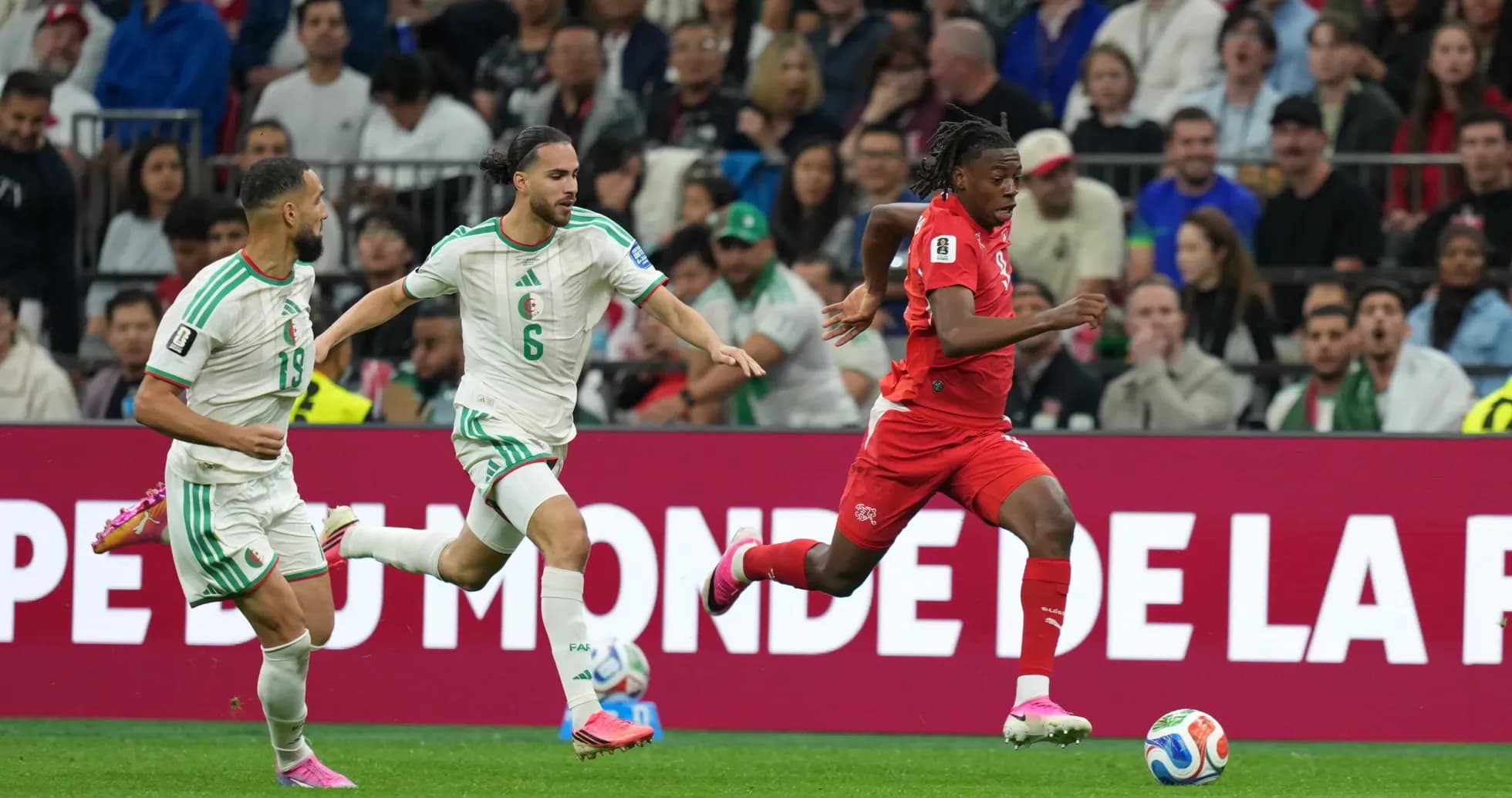 Switzerland player sprinting past Algeria defenders Switzerland player sprinting past Algeria defenders