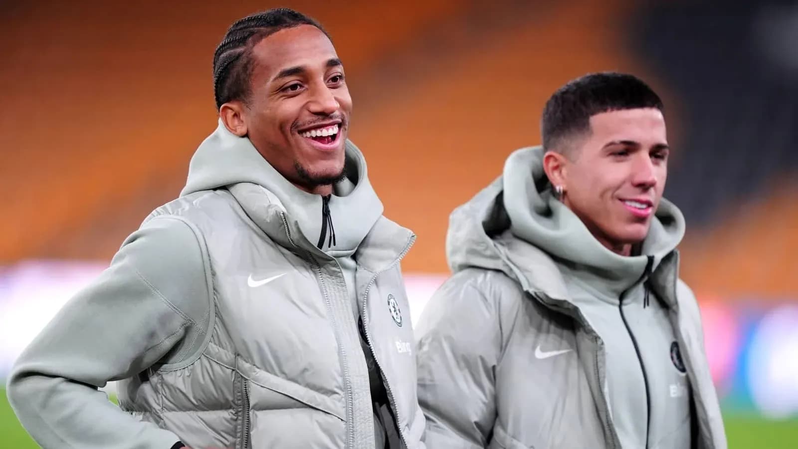 Two players smiling during warm-up in training jackets Two players smiling during warm-up in training jackets