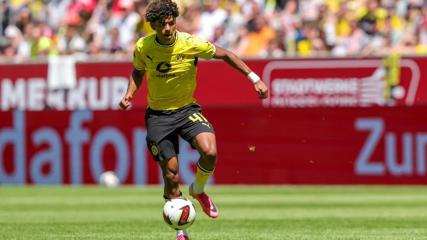 Player in yellow kit dribbling the ball on field Player in yellow kit dribbling the ball on field