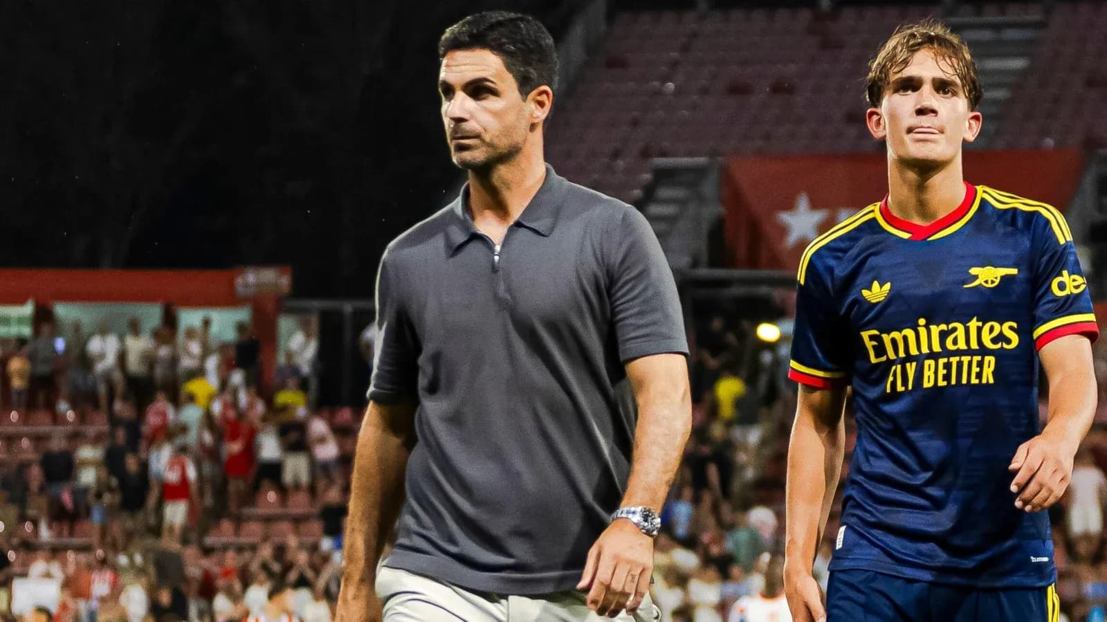 Coach and player walking off the pitch after match Coach and player walking off the pitch after match