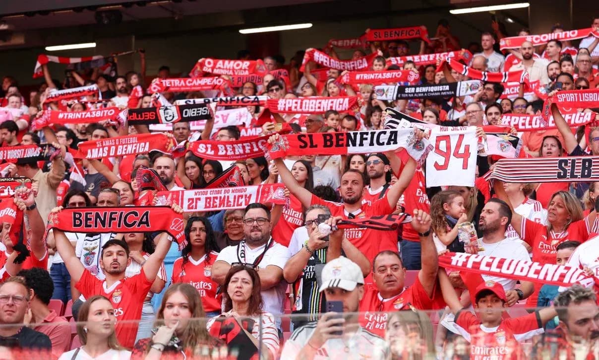 Benfica fans celebrating with scarves in stadium Benfica fans celebrating with scarves in stadium