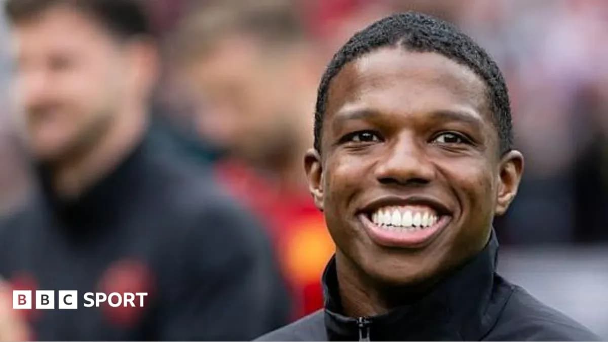 Smiling player in black jacket on field Smiling player in black jacket on field