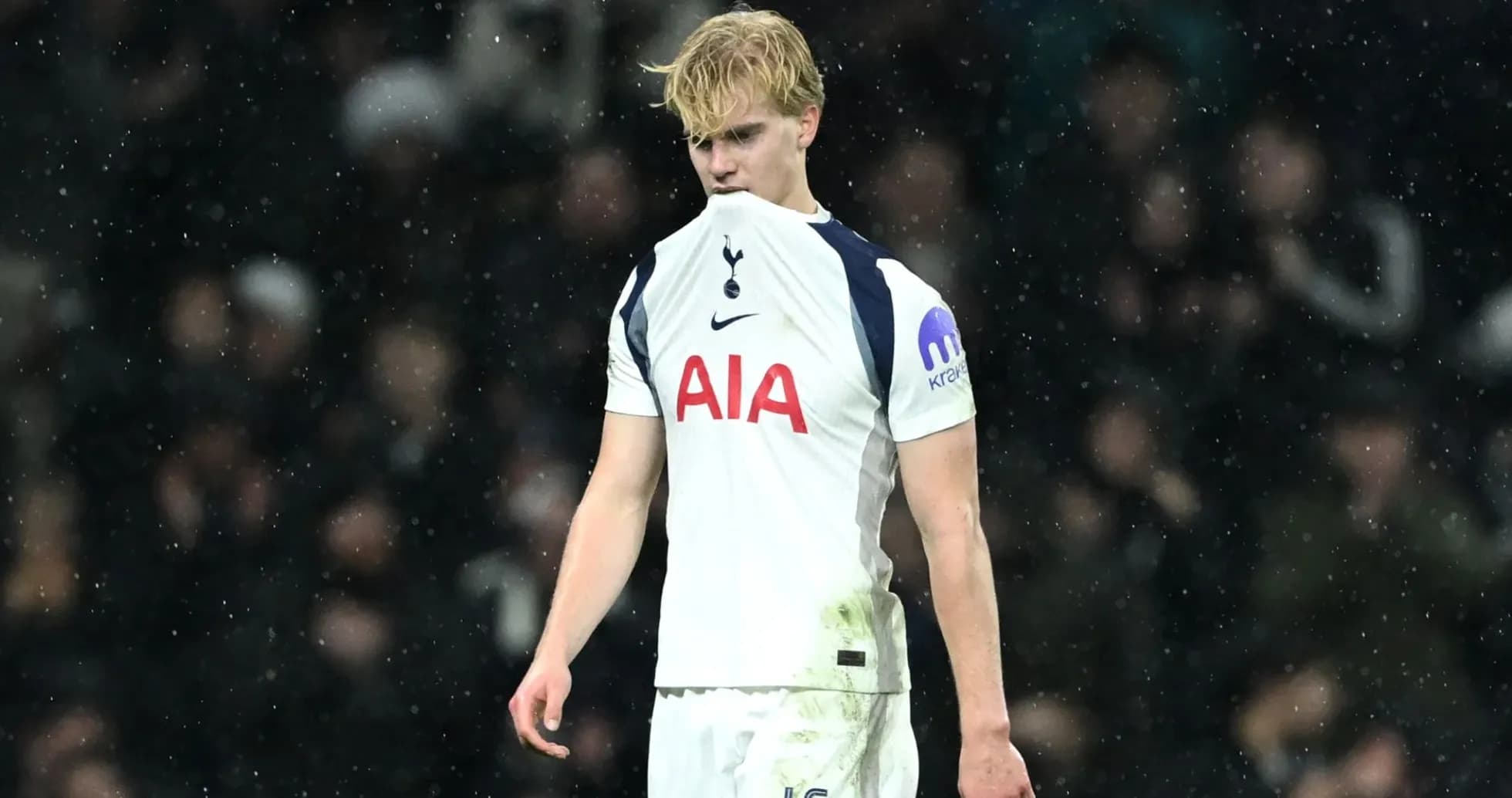Player in Tottenham kit walking on a rainy pitch Player in Tottenham kit walking on a rainy pitch