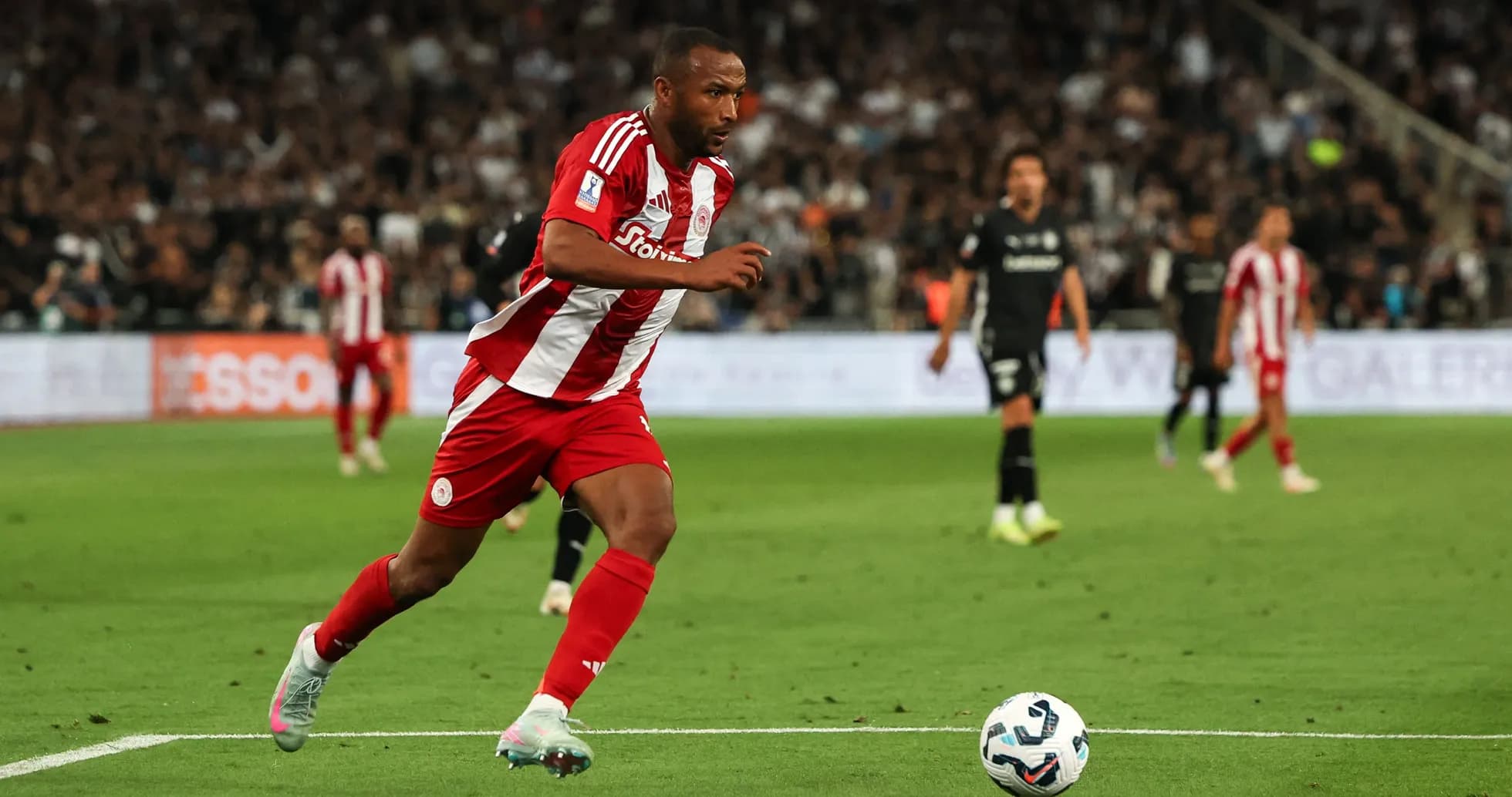 Player in red and white sprinting towards the ball Player in red and white sprinting towards the ball