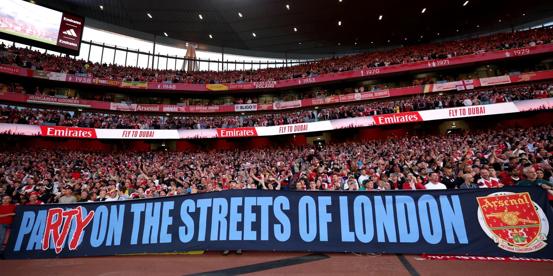 Arsenal fans celebrating with a large banner Arsenal fans celebrating with a large banner