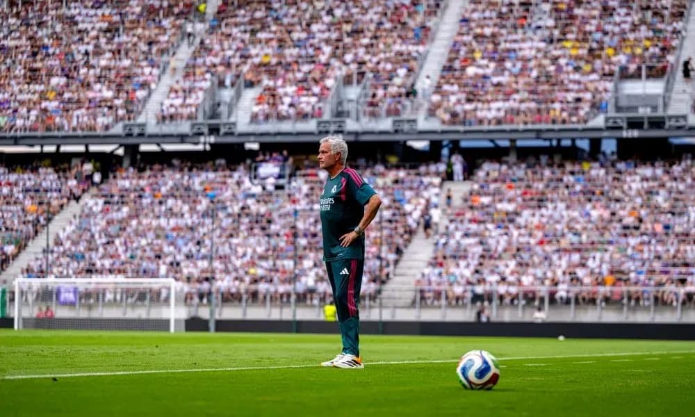 Coach observing match from sidelines in crowded stadium Coach observing match from sidelines in crowded stadium