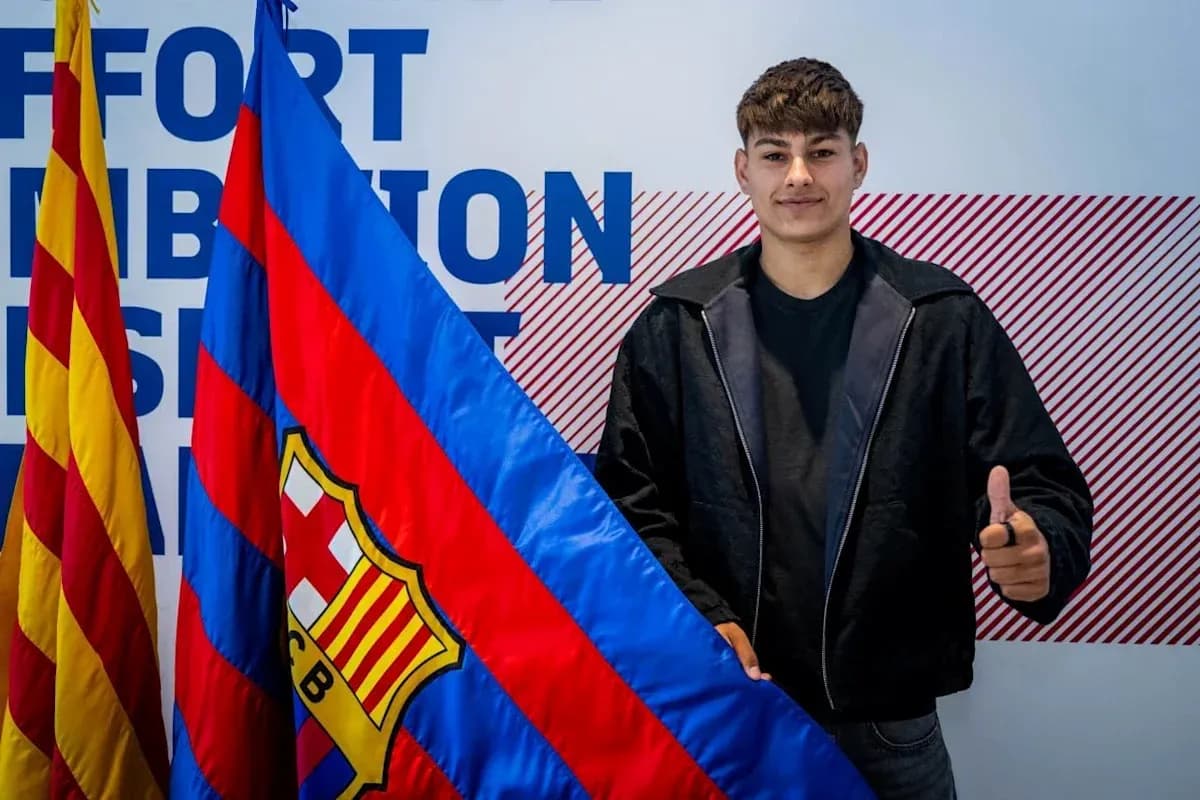 Player posing with FC Barcelona flag during signing event Player posing with FC Barcelona flag during signing event