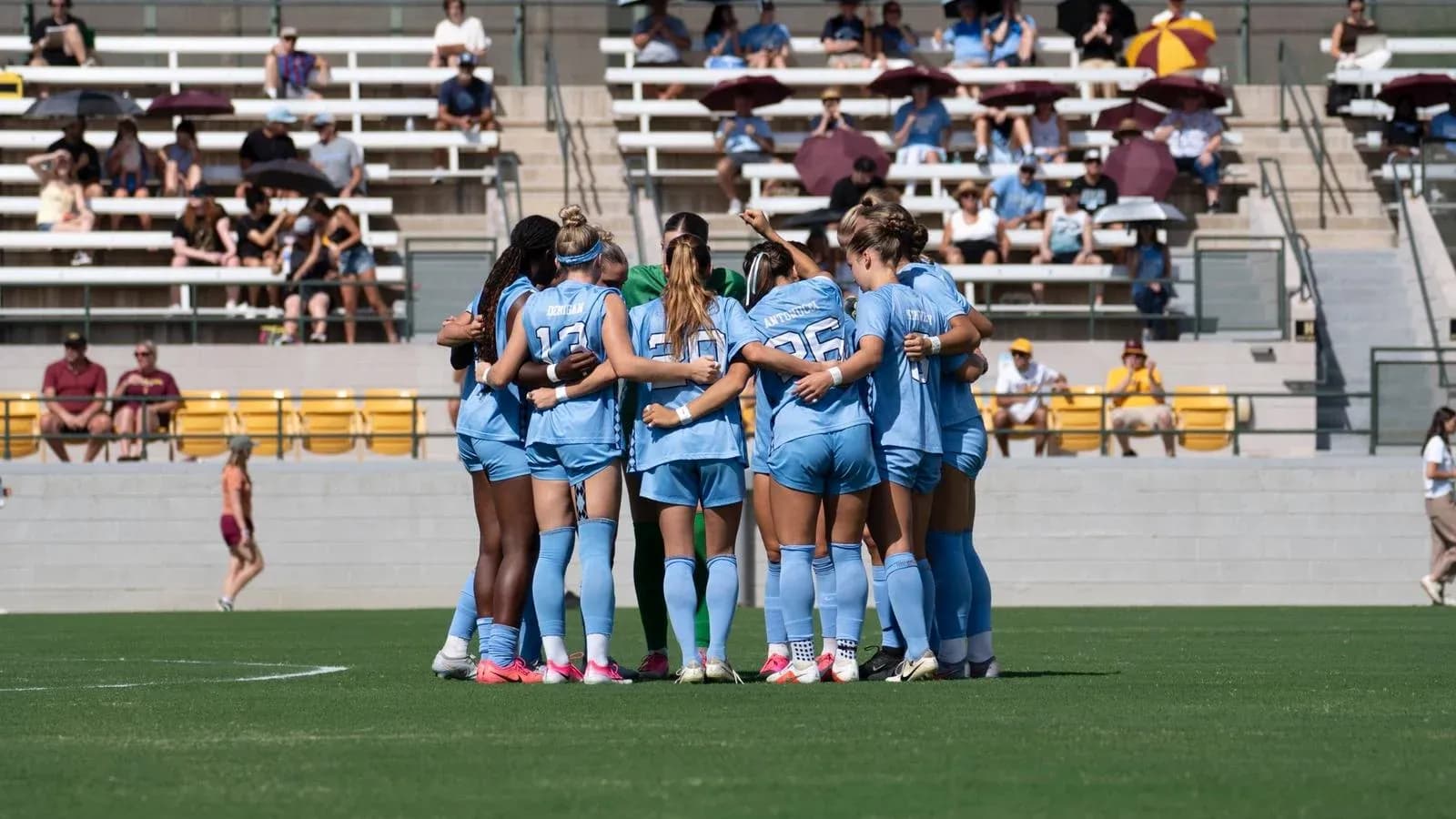Women's soccer team huddled before the match Women's soccer team huddled before the match