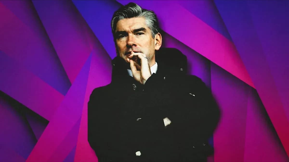 Man in black coat with hand on chin Man in black coat with hand on chin