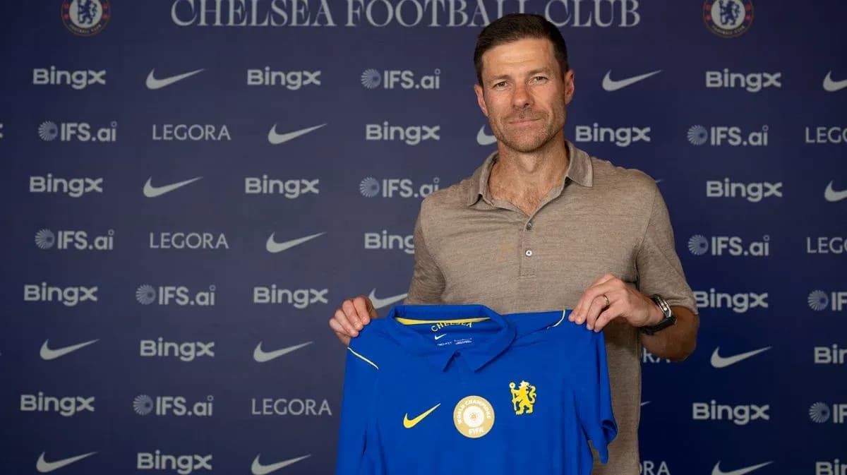New manager holding Chelsea jersey at press conference New manager holding Chelsea jersey at press conference
