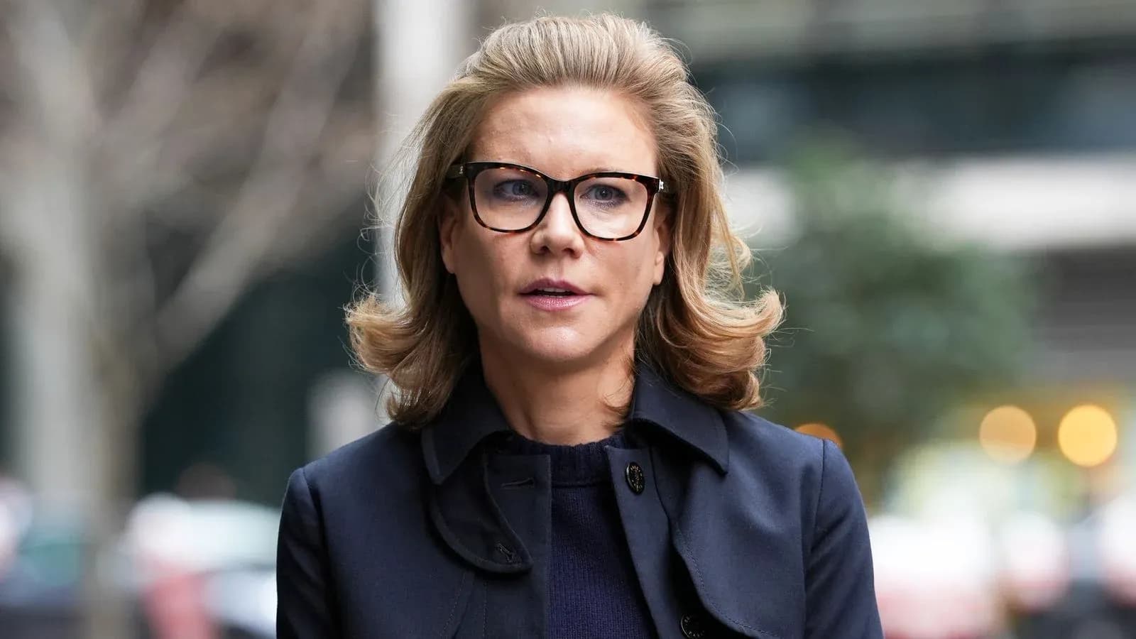 Woman with glasses walking in urban setting Woman with glasses walking in urban setting