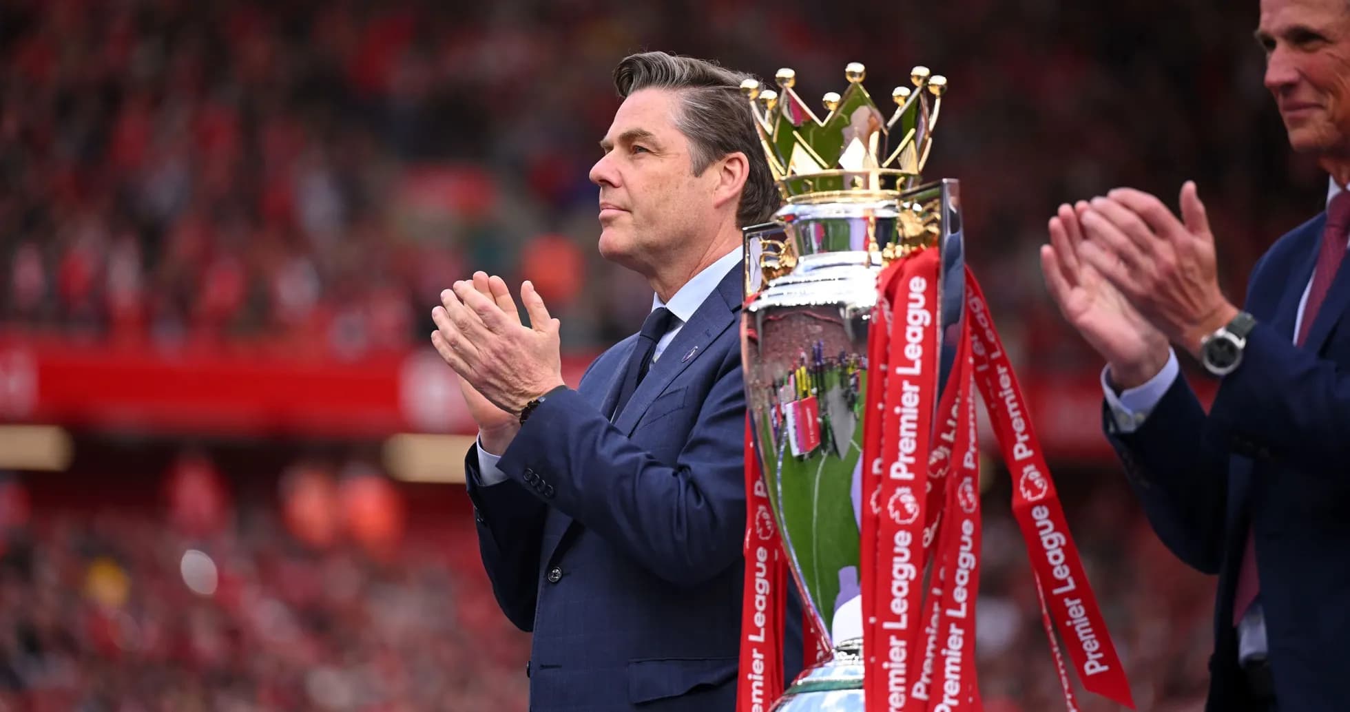 Man applauding next to Premier League trophy presentation Man applauding next to Premier League trophy presentation