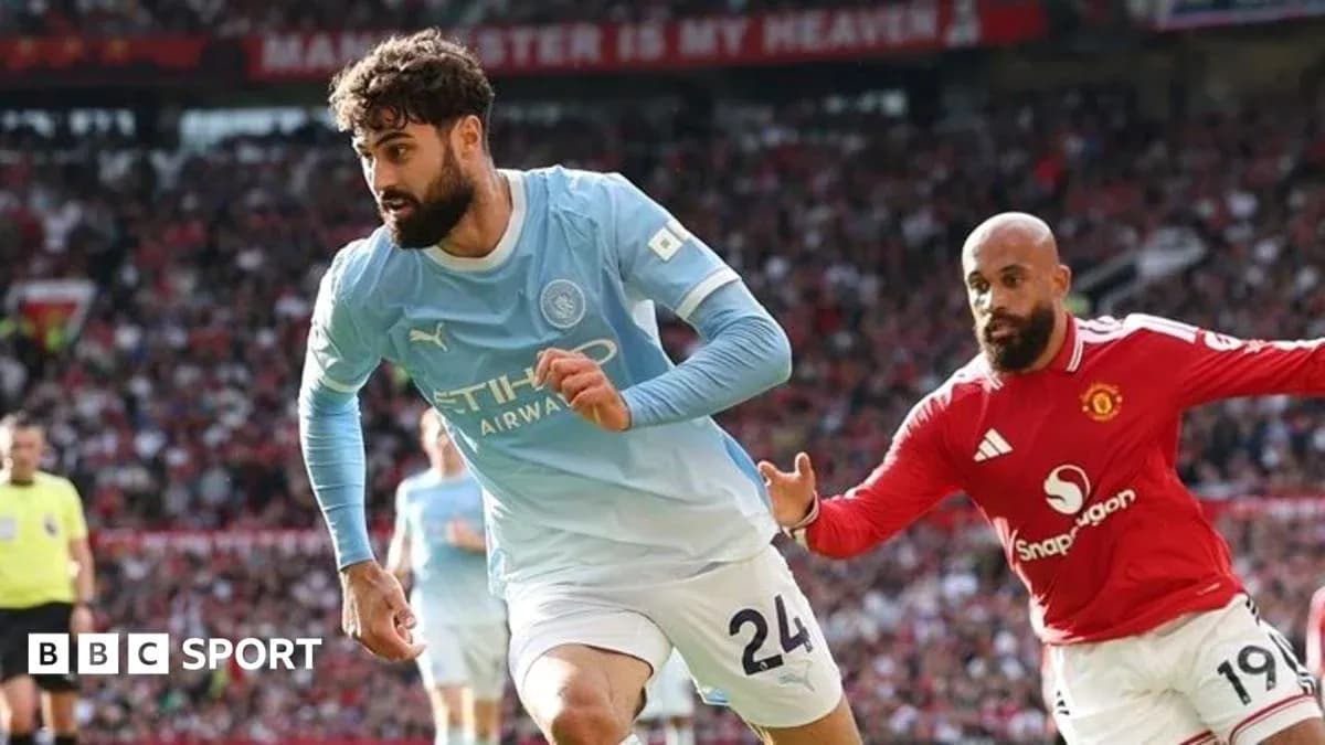 Manchester City player running past Manchester United opponent Manchester City player running past Manchester United opponent