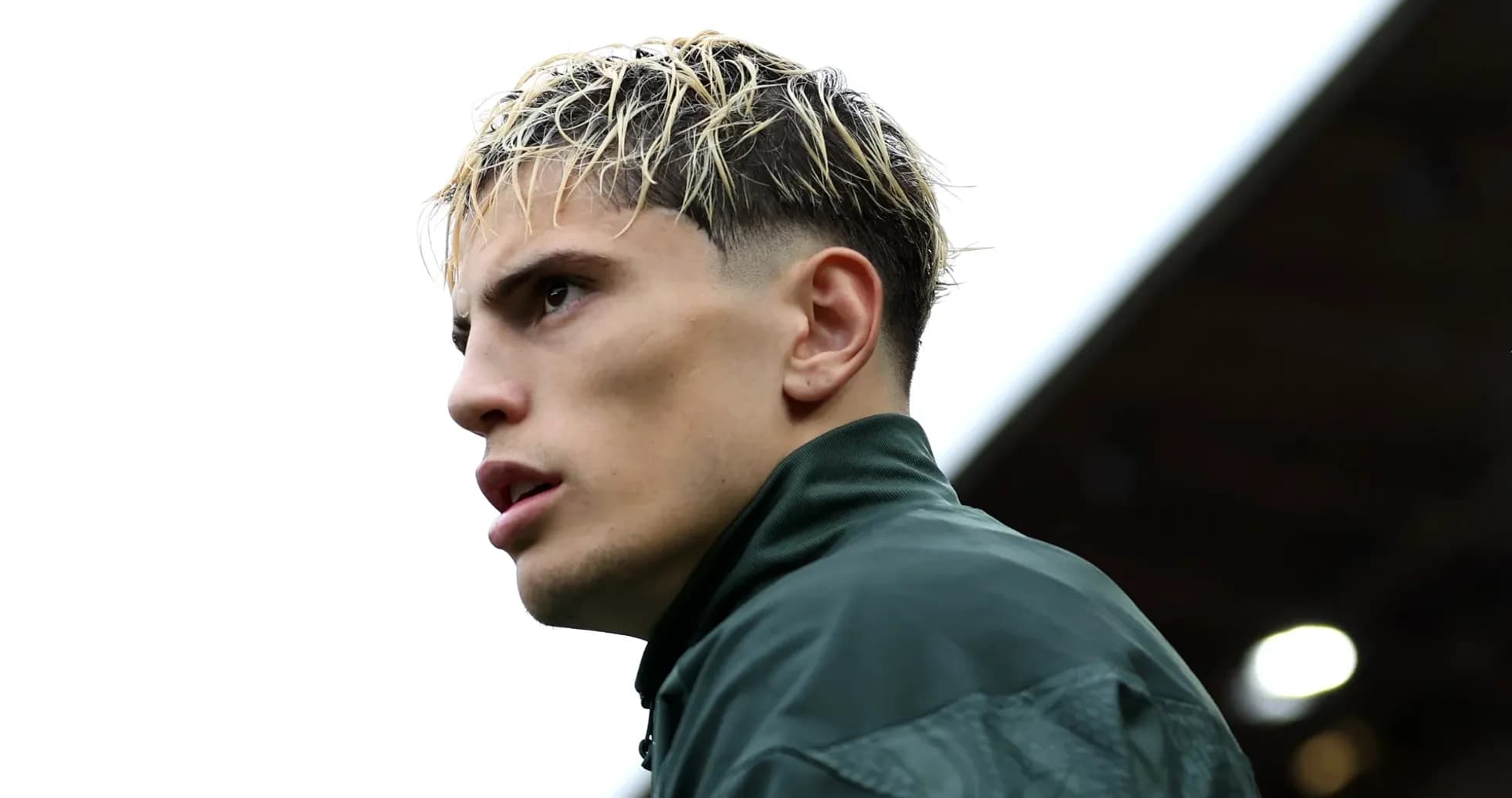 Player with slicked hair wearing a green jacket Player with slicked hair wearing a green jacket