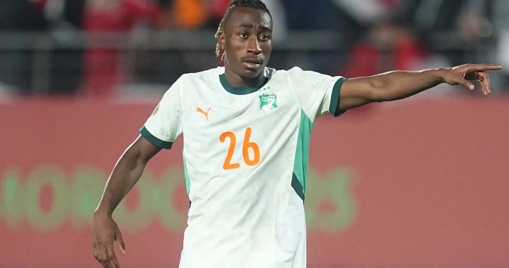 Player in Ivory Coast jersey directing teammates on field Player in Ivory Coast jersey directing teammates on field