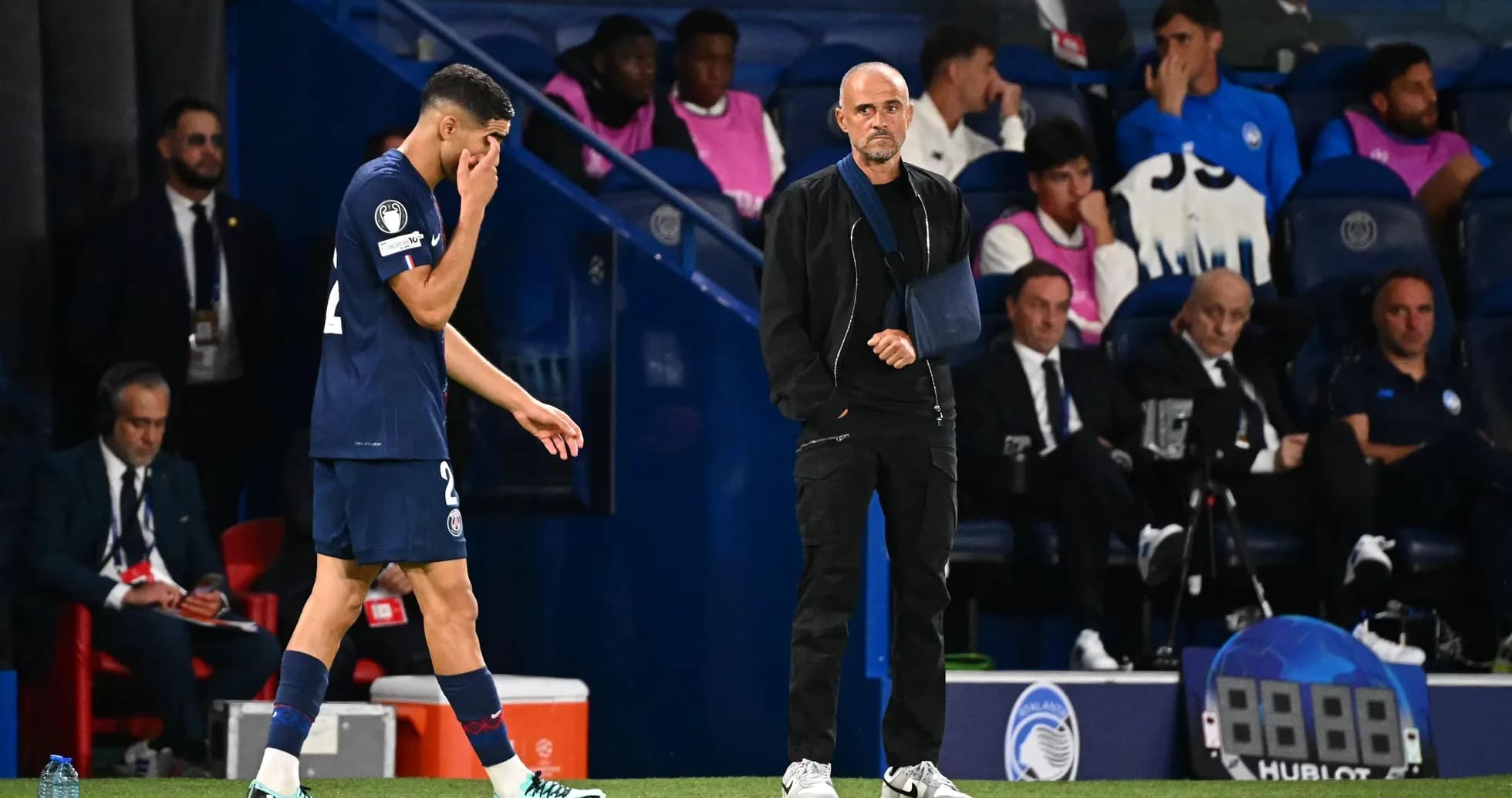 Player leaving pitch while coach observes during match Player leaving pitch while coach observes during match