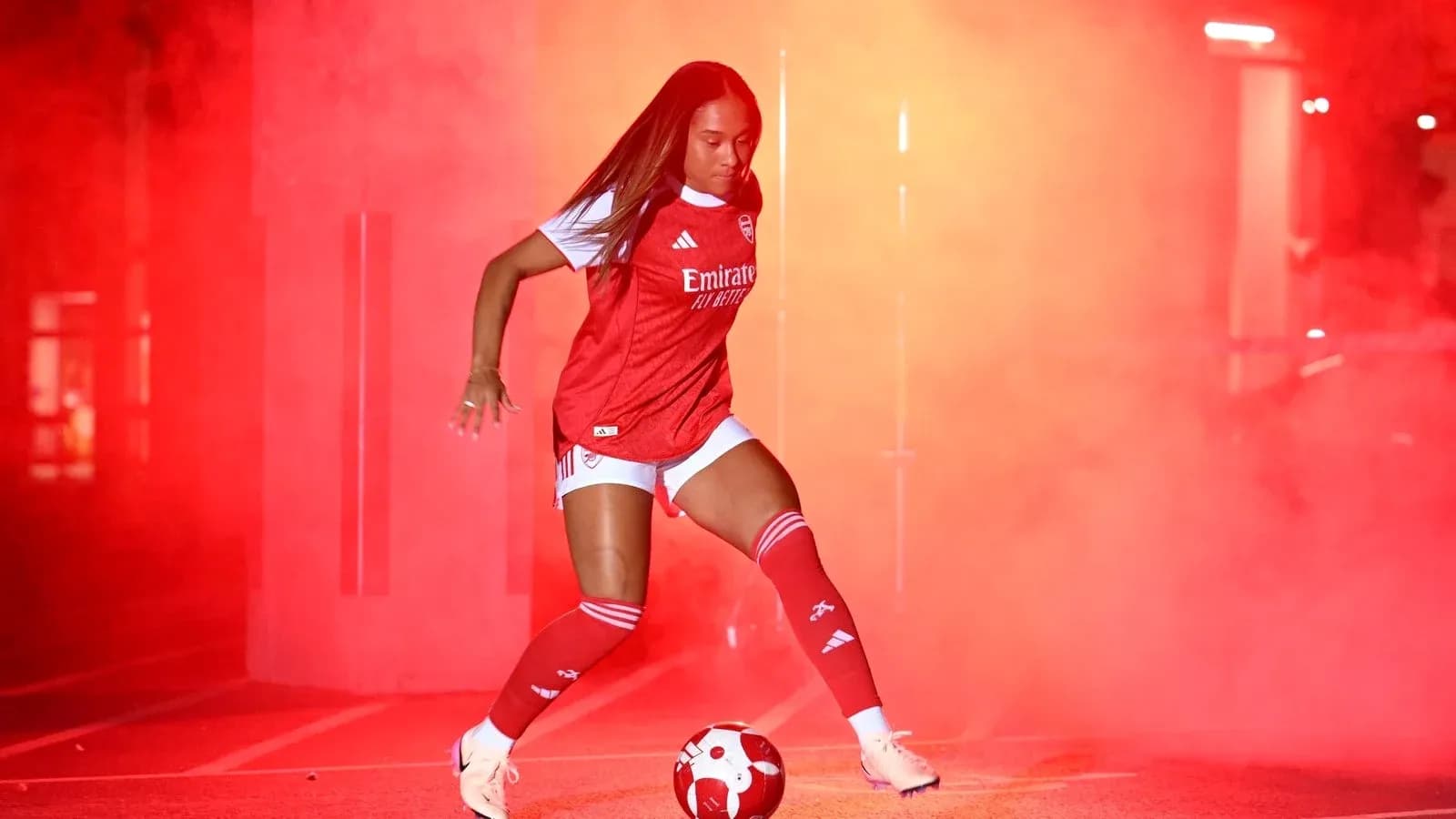 Player in Arsenal kit kicking a soccer ball Player in Arsenal kit kicking a soccer ball