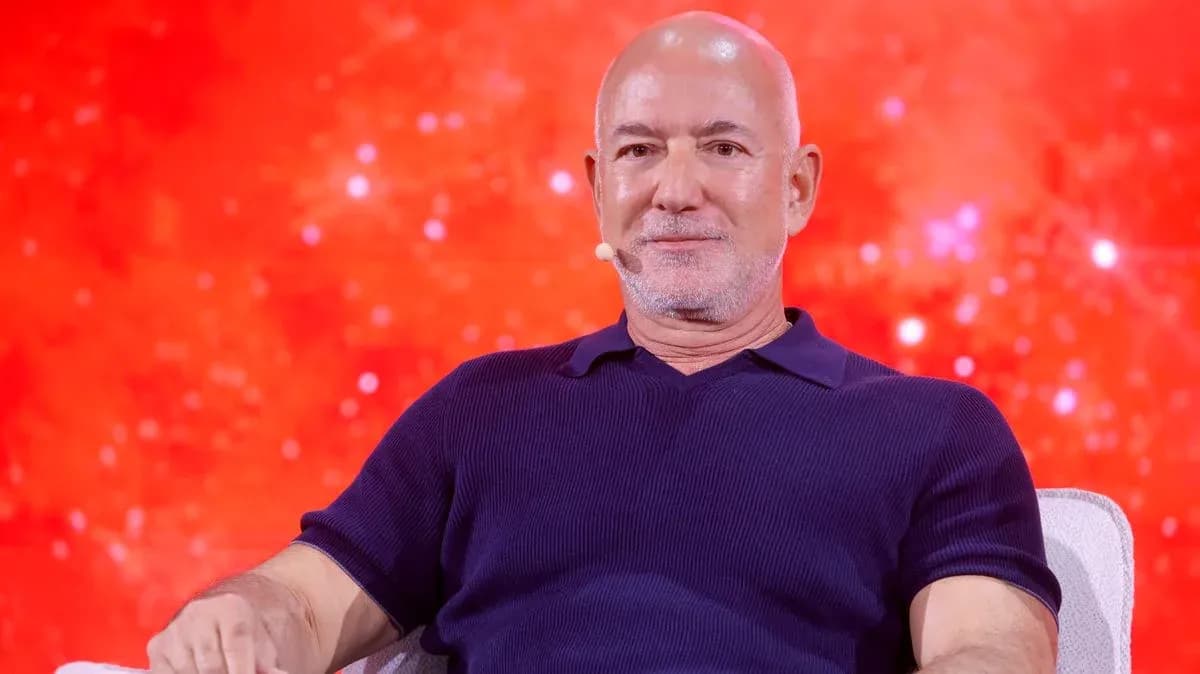 Person speaking on stage with red background Person speaking on stage with red background