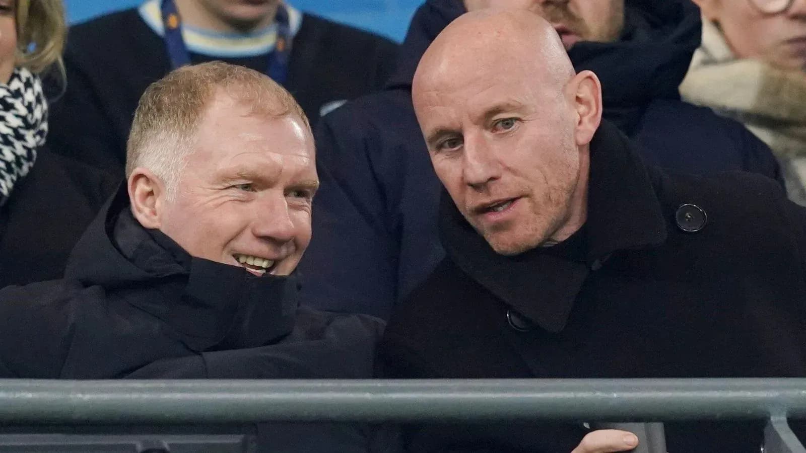Two men conversing in the stands at a match Two men conversing in the stands at a match