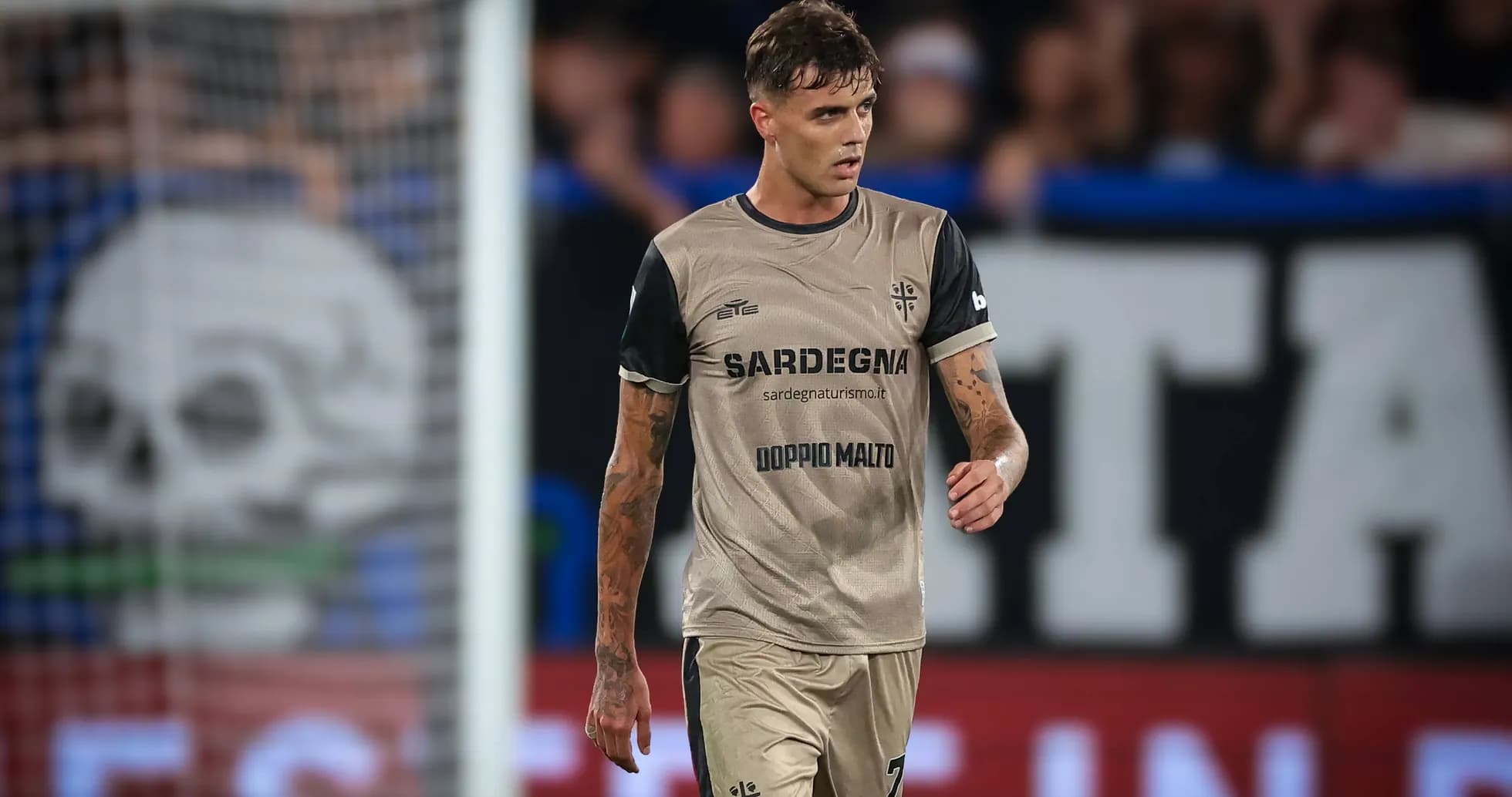 Player in beige kit walking on the pitch Player in beige kit walking on the pitch
