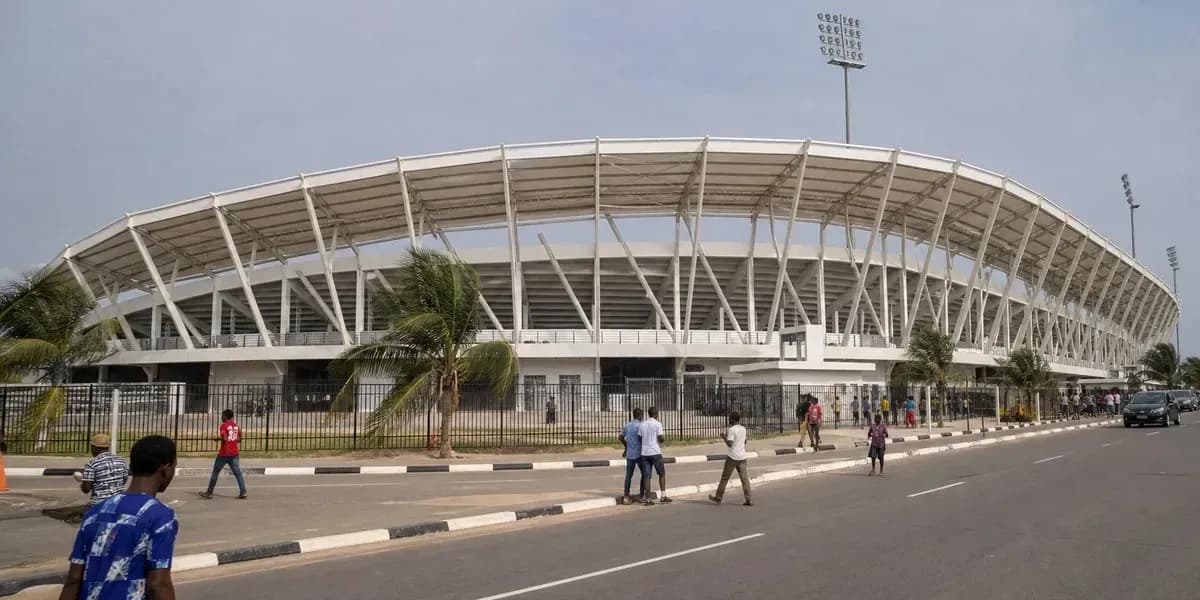 Exterior view of a stadium with pedestrians nearby Exterior view of a stadium with pedestrians nearby