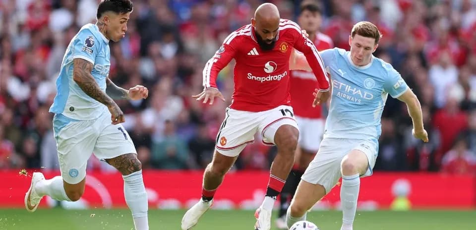 Manchester United player challenged by Manchester City opponents Manchester United player challenged by Manchester City opponents
