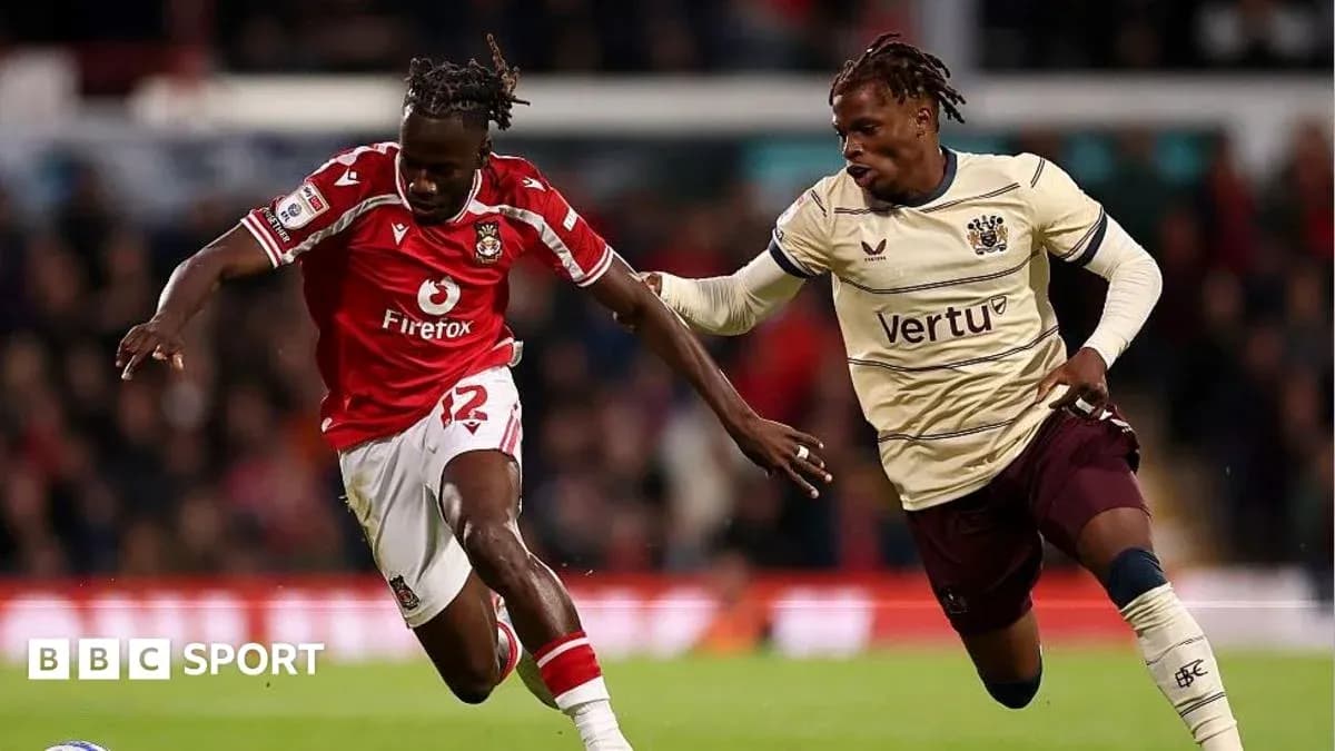 Player in red jersey dribbling past opponent in beige jersey Player in red jersey dribbling past opponent in beige jersey