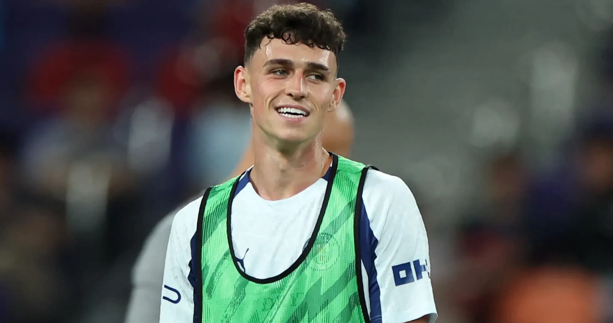 Player smiling in training bib on the pitch Player smiling in training bib on the pitch