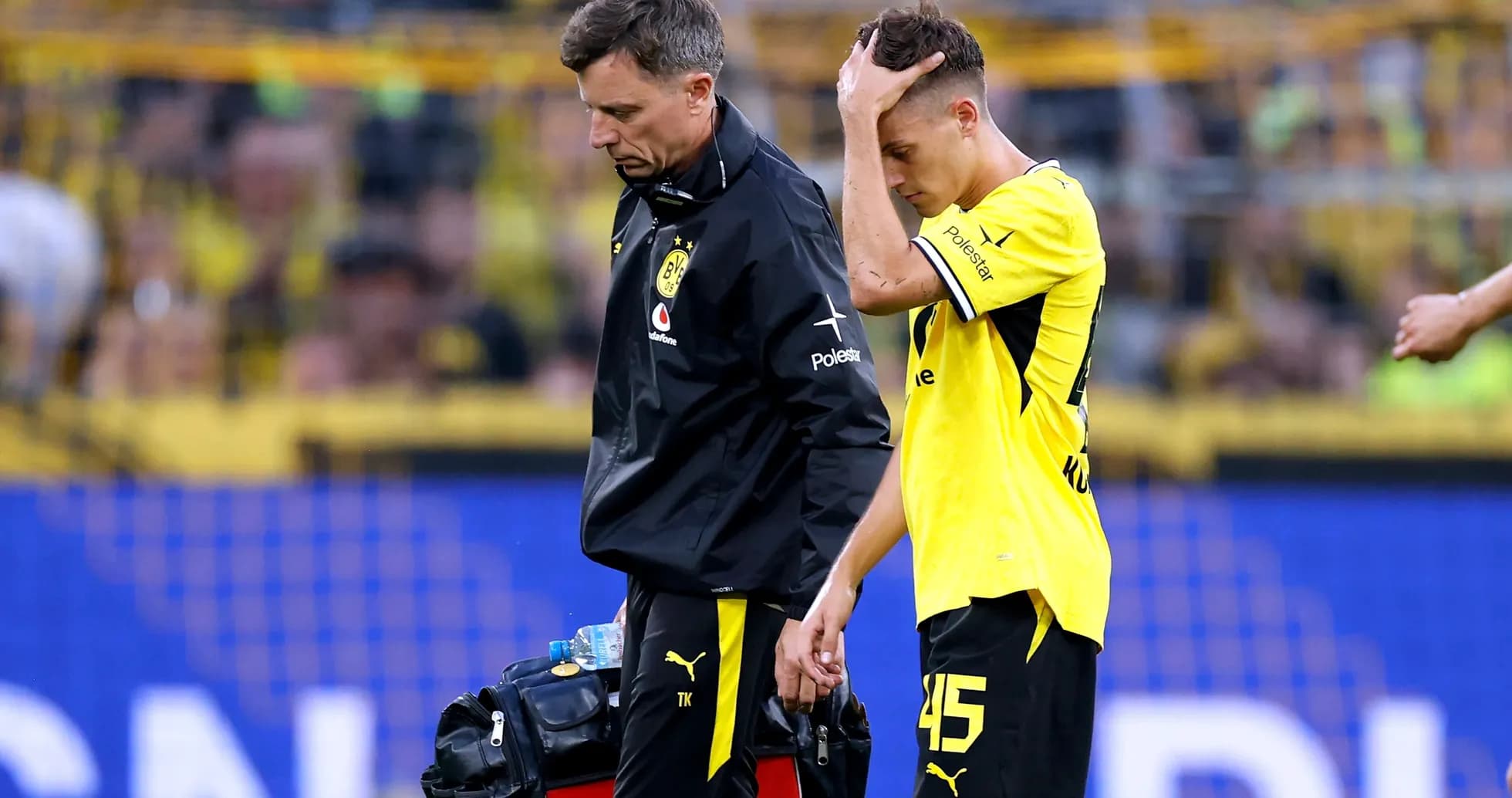 Player being assisted off the field by staff Player being assisted off the field by staff