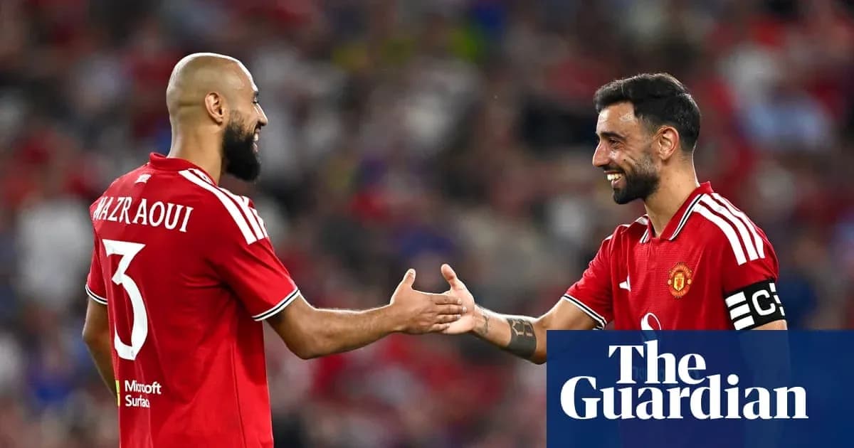 Two Manchester United players shaking hands on pitch Two Manchester United players shaking hands on pitch