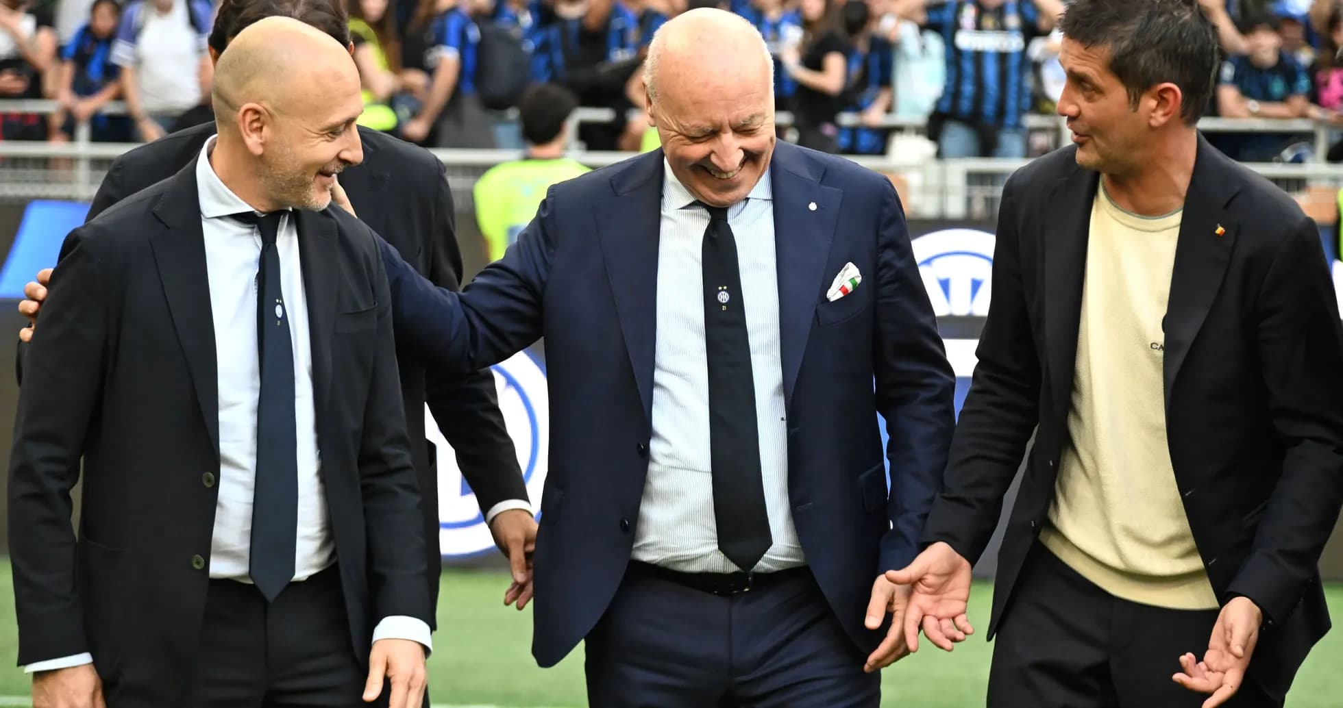 Three coaches interacting on the pitch before match Three coaches interacting on the pitch before match
