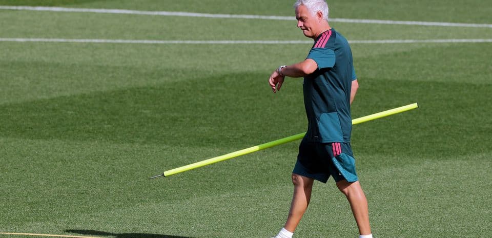 Coach walking with training pole on pitch Coach walking with training pole on pitch