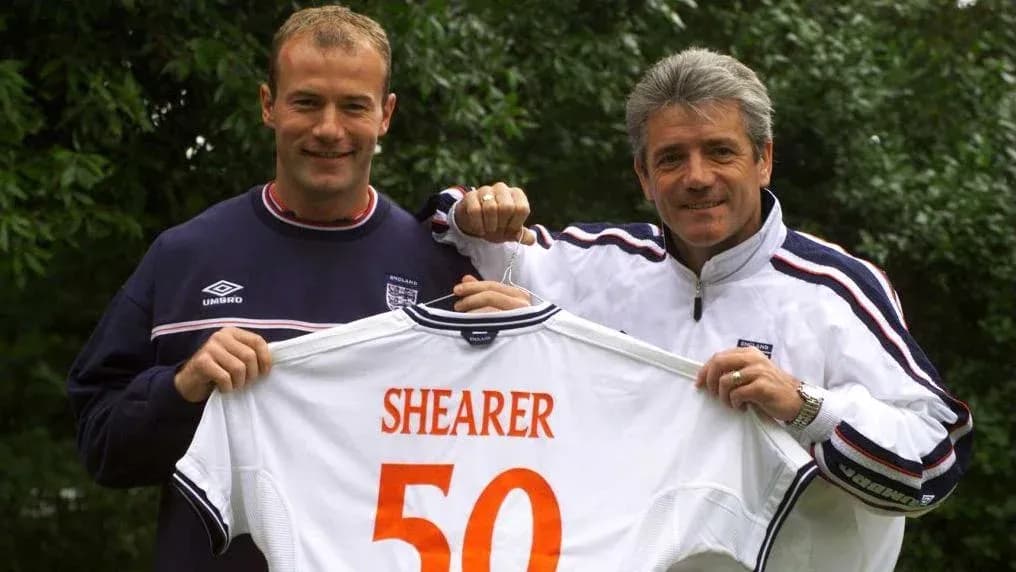 Two men holding a jersey with 'SHEARER 50' Two men holding a jersey with 'SHEARER 50'
