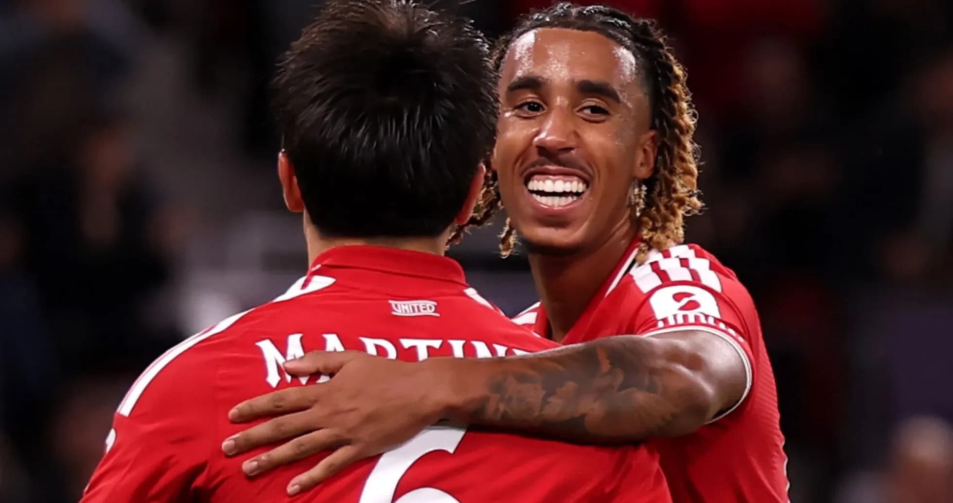 Two players celebrating in red jerseys after a goal Two players celebrating in red jerseys after a goal