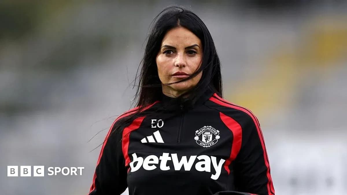 Woman in Manchester United training kit on field Woman in Manchester United training kit on field