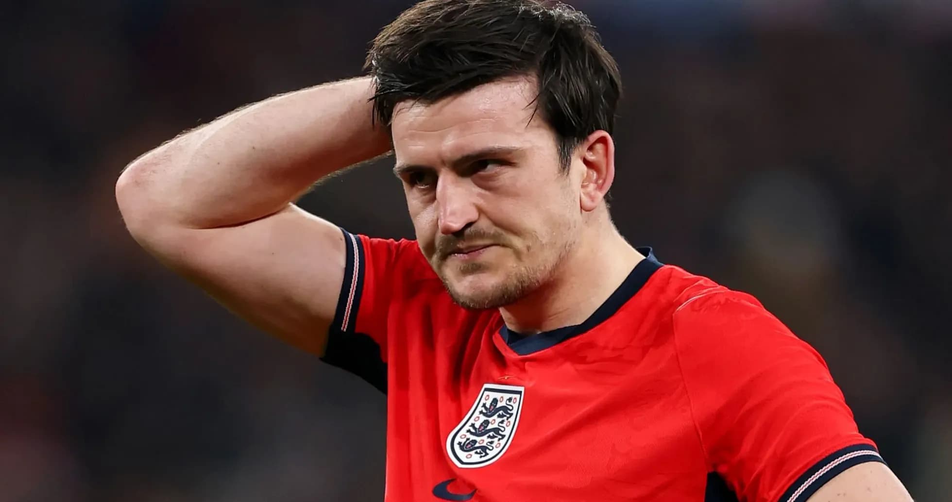Player in red jersey with England badge looks concerned Player in red jersey with England badge looks concerned