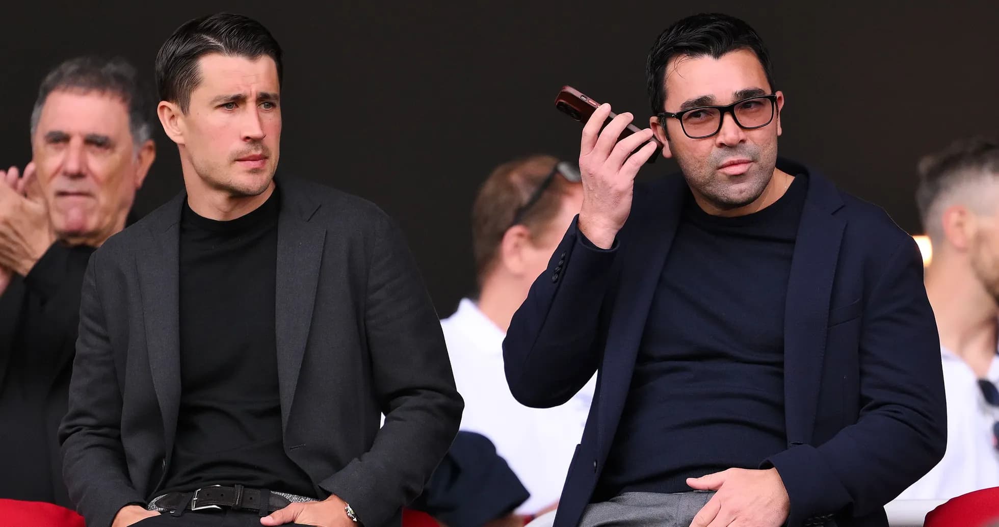 Two men sitting in stands during an event Two men sitting in stands during an event