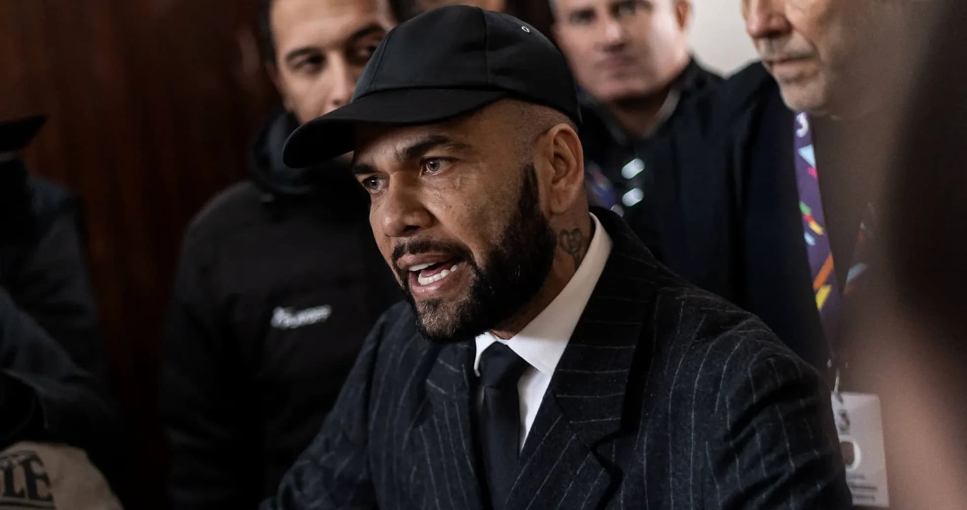 Man in suit speaking surrounded by onlookers Man in suit speaking surrounded by onlookers