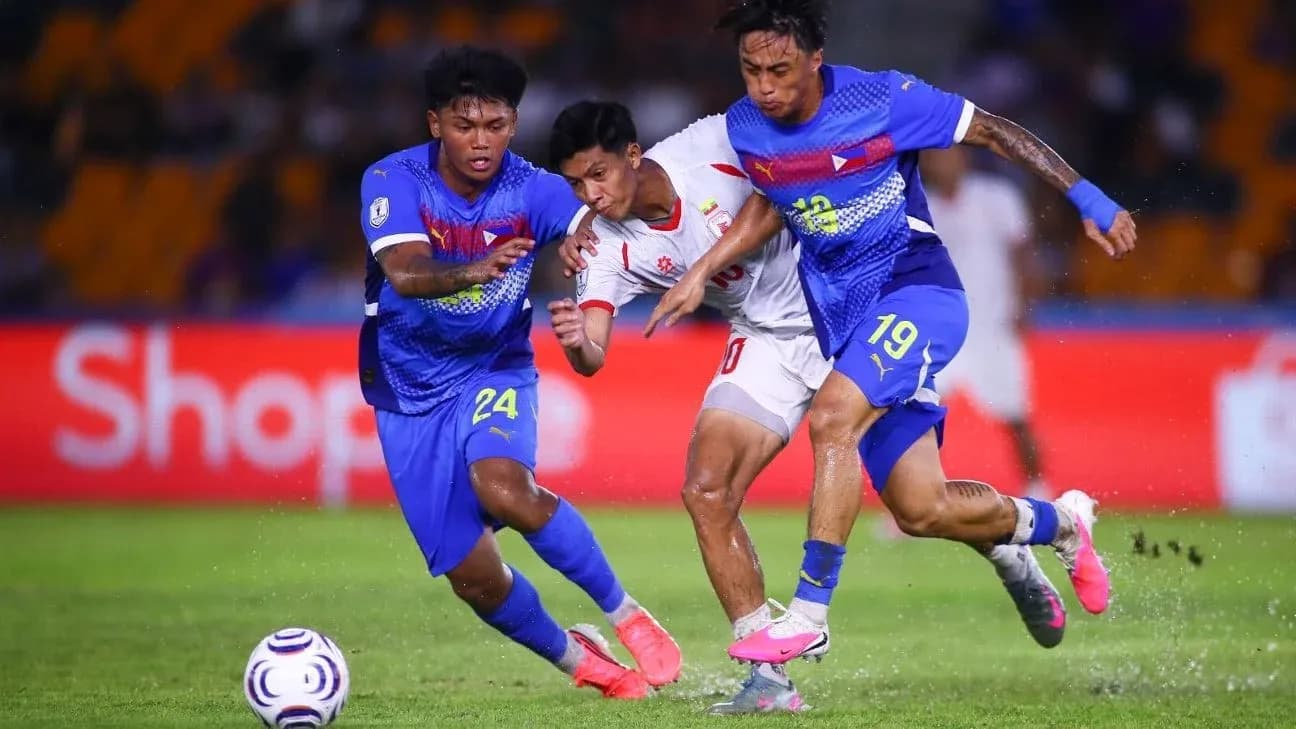 Two players tackling opponent during football match Two players tackling opponent during football match