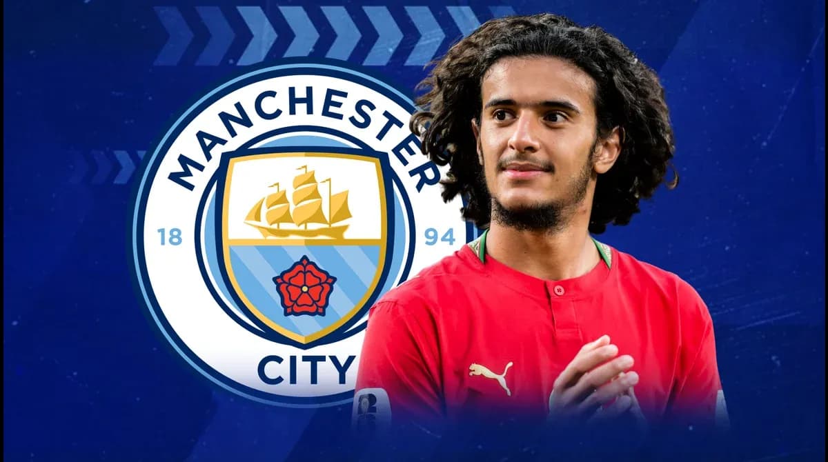 Player in red jersey with Manchester City logo background Player in red jersey with Manchester City logo background