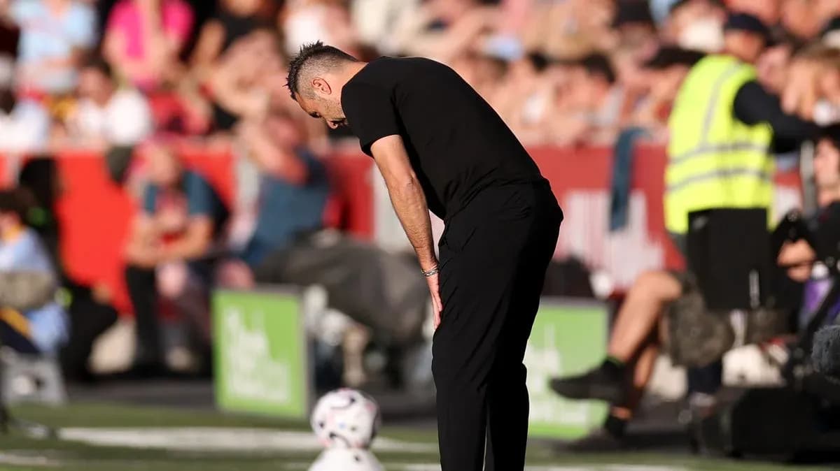 Coach observing the game with head bowed Coach observing the game with head bowed
