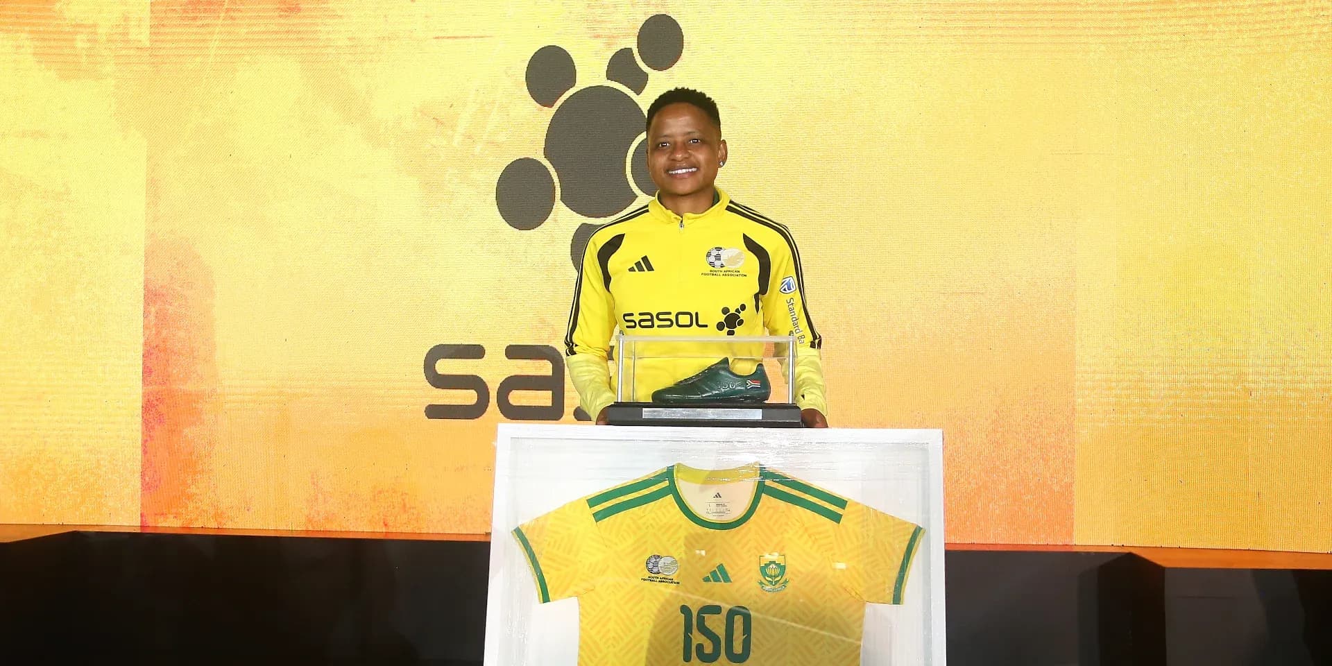 Player presenting commemorative jersey and soccer boot Player presenting commemorative jersey and soccer boot