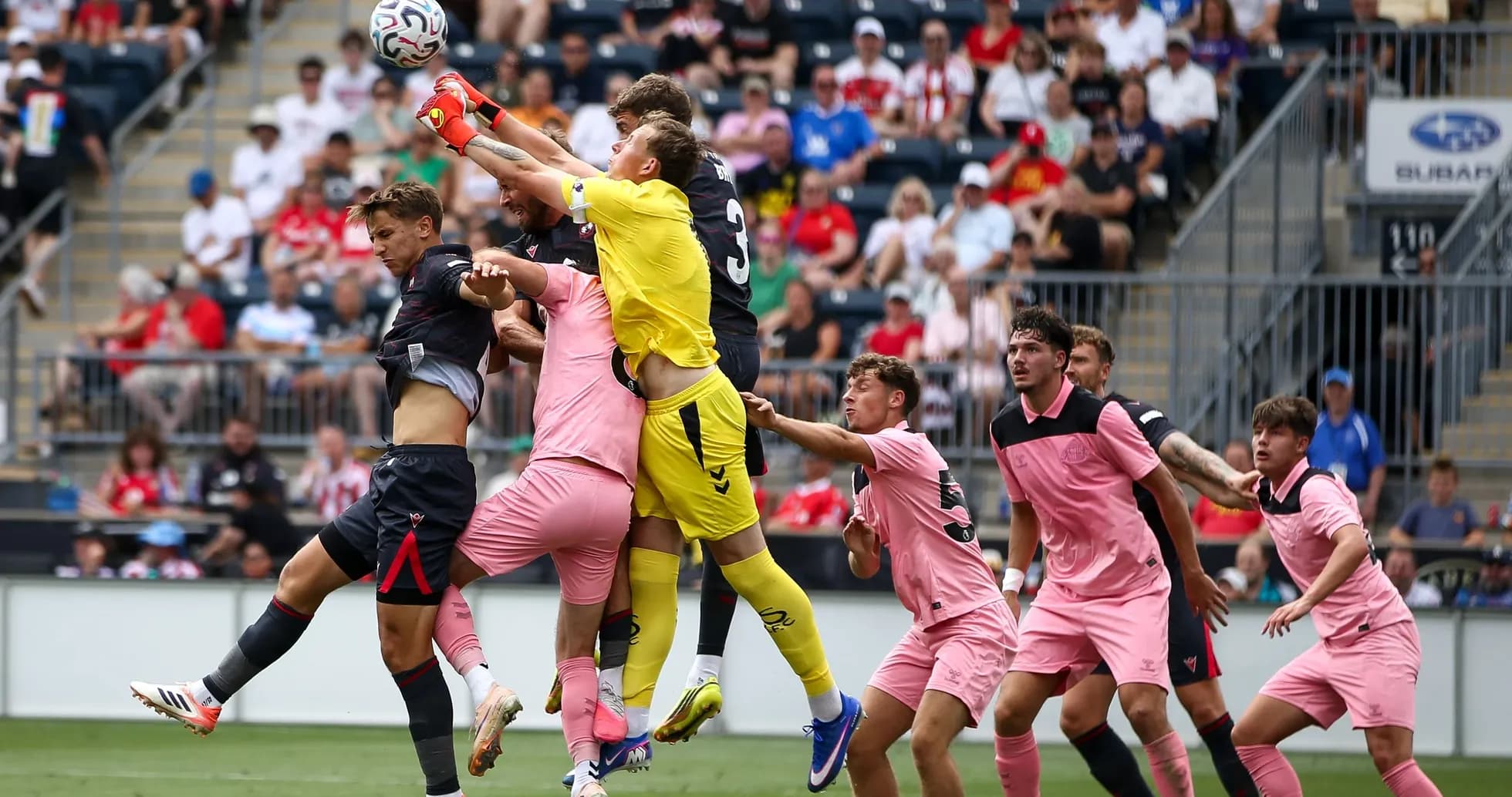Goalkeeper jumping to catch the ball amidst players Goalkeeper jumping to catch the ball amidst players